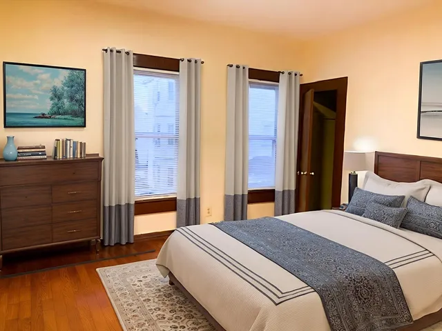 a bedroom with a bed cabinet and mirror