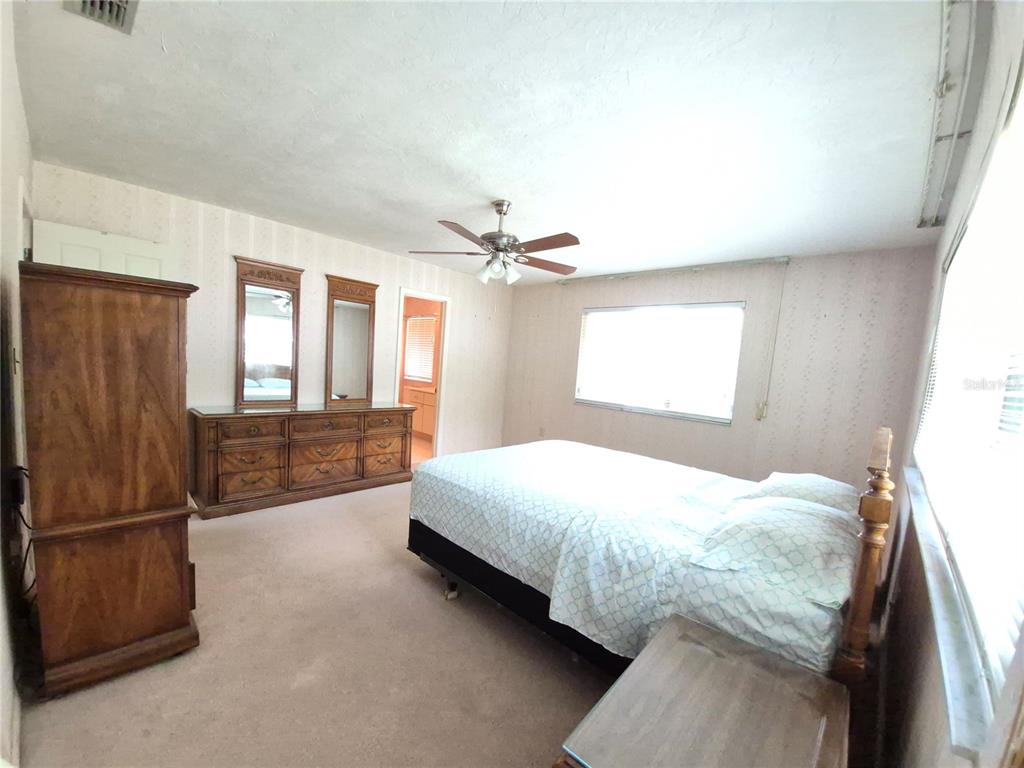 25632 Southwest 19 Avenue Newberry, FL 32669 - Photo 11 of 20 a bedroom with a large bed and a chandelier
