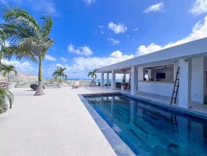 a view of a house with swimming pool and sitting area