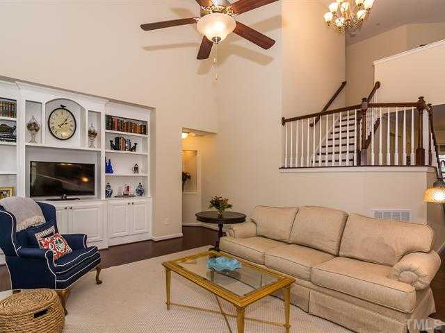 2903 Red Grape Drive Raleigh, NC 27607 - Photo 11 of 25 a living room with furniture a flat screen tv and a clock