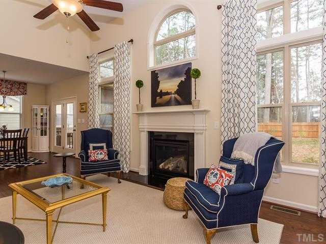 2903 Red Grape Drive Raleigh, NC 27607 - Photo 13 of 25 a living room with furniture a flat screen tv and a fireplace