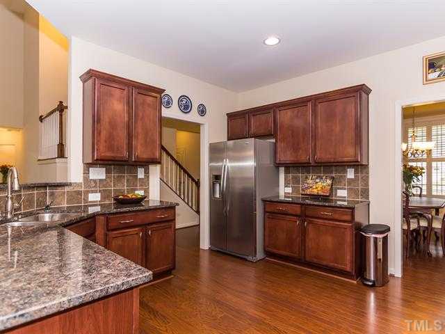 2903 Red Grape Drive Raleigh, NC 27607 - Photo 7 of 25 a kitchen with stainless steel appliances granite countertop a sink stove and refrigerator