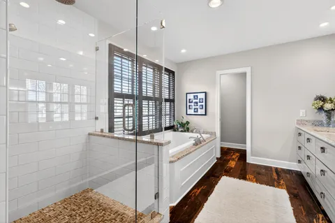 a spacious bathroom with a double vanity sink a large mirror and shower