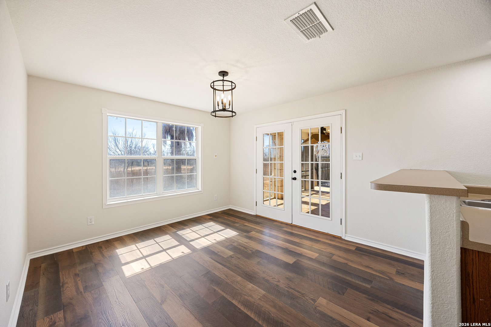 18181 Senior Road Von Ormy, TX 78073 - Photo 13 of 46 a view of an empty room with wooden floor and a window