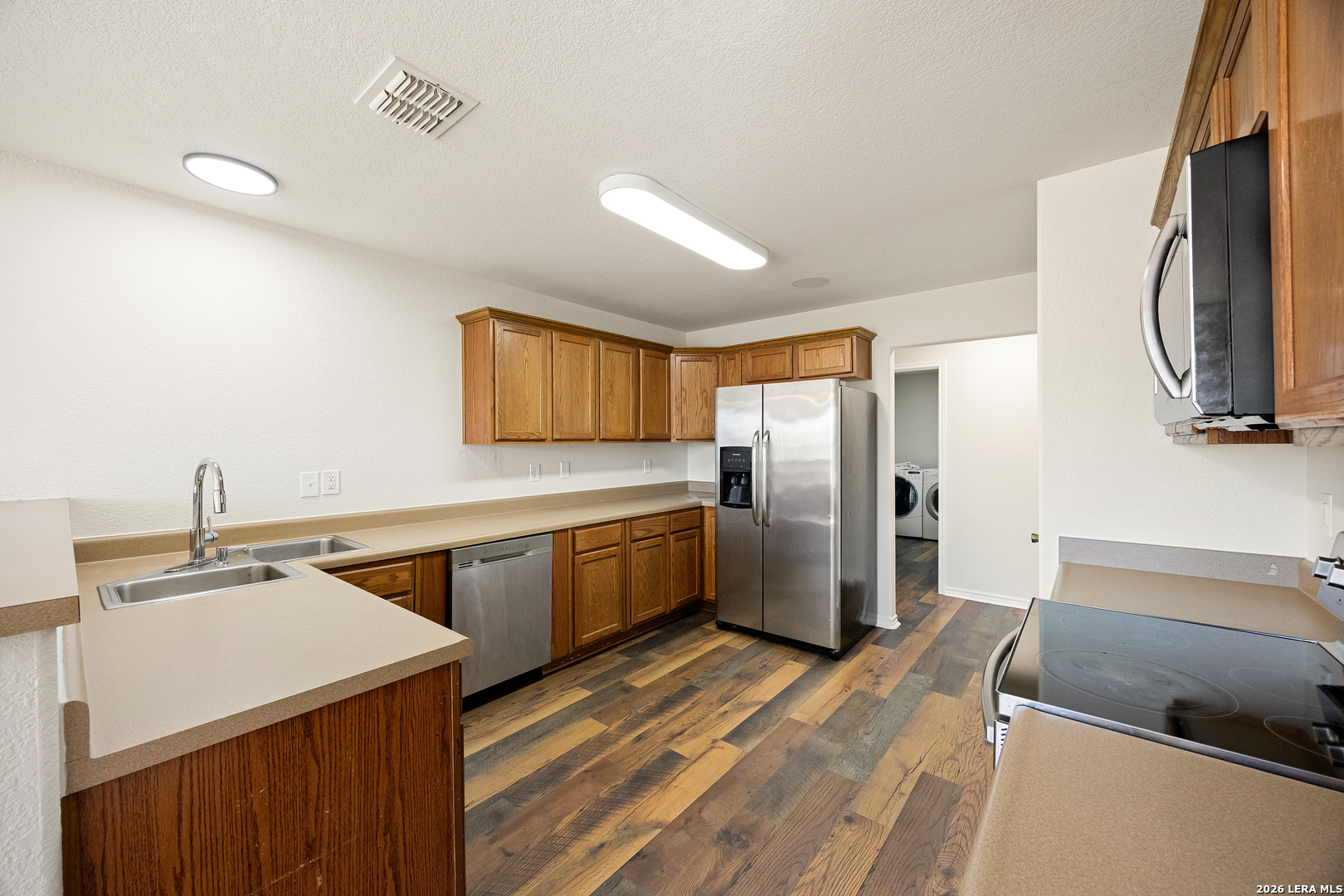18181 Senior Road Von Ormy, TX 78073 - Photo 15 of 46 a kitchen with a sink a counter top space stainless steel appliances and cabinets