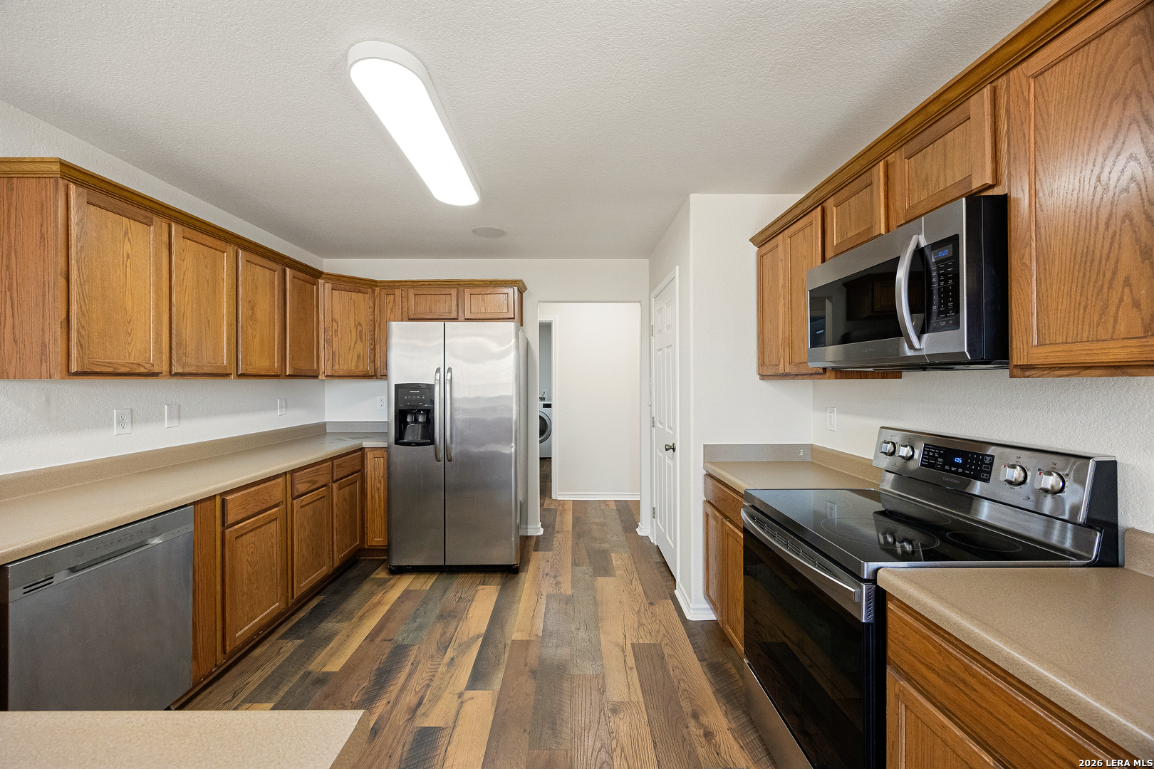 18181 Senior Road Von Ormy, TX 78073 - Photo 18 of 46 a kitchen with stainless steel appliances a stove microwave and sink