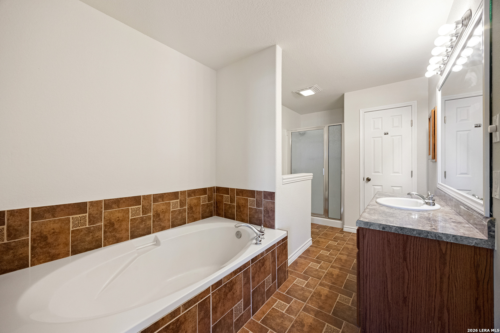 18181 Senior Road Von Ormy, TX 78073 - Photo 24 of 46 a bathroom with a tub a sink and a mirror