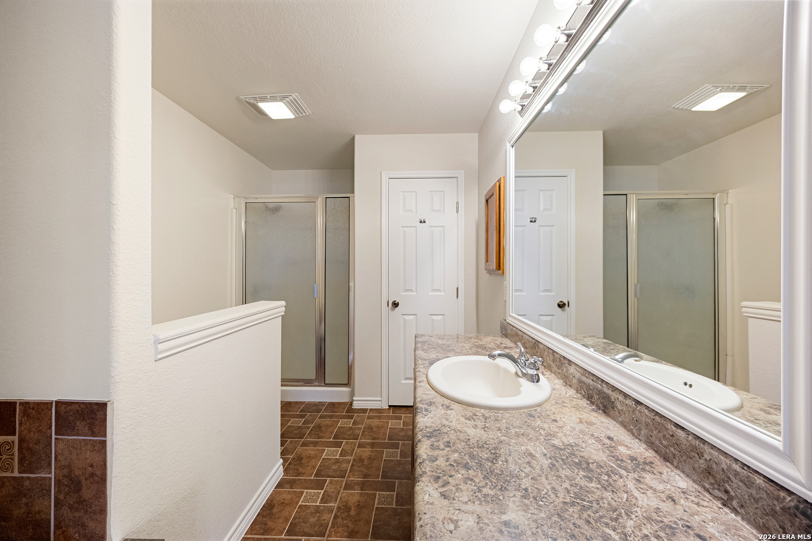 18181 Senior Road Von Ormy, TX 78073 - Photo 25 of 46 a bathroom with a sink a mirror and a shower