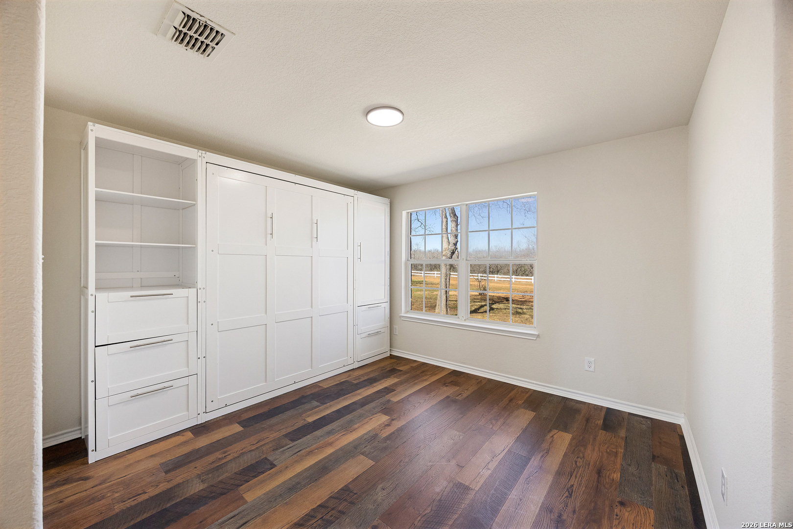 18181 Senior Road Von Ormy, TX 78073 - Photo 8 of 46 an empty room with wooden floor and windows