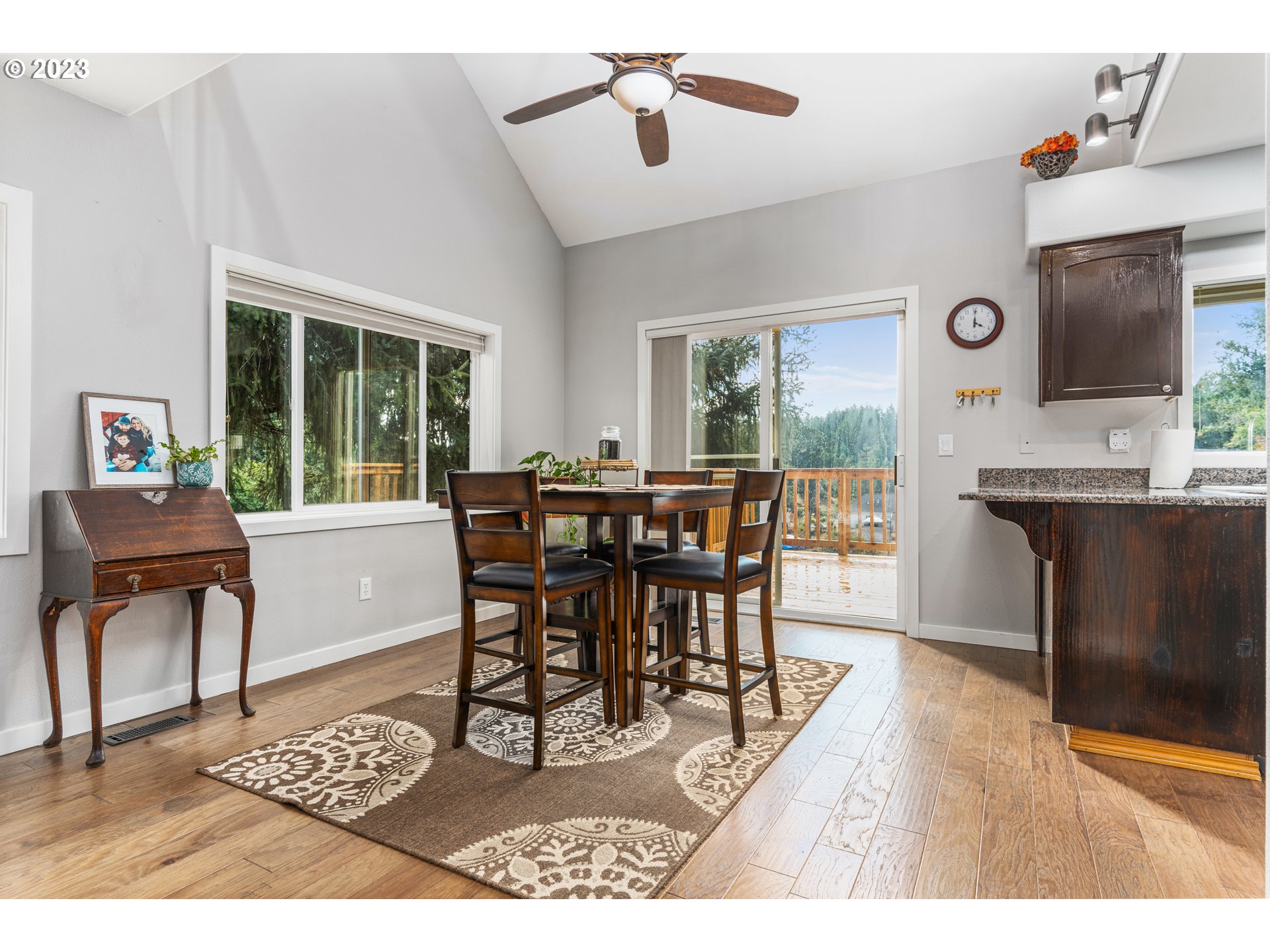 5963 Timber Ridge Drive Southeast Salem, OR 97317 - Photo 11 of 39 a dining room with wooden floor a chandelier a wooden table and chairs