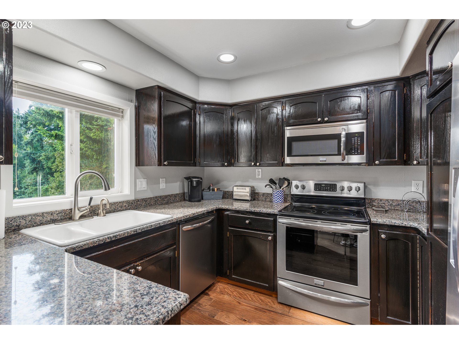 5963 Timber Ridge Drive Southeast Salem, OR 97317 - Photo 18 of 39 a kitchen with stainless steel appliances granite countertop a sink stove and microwave