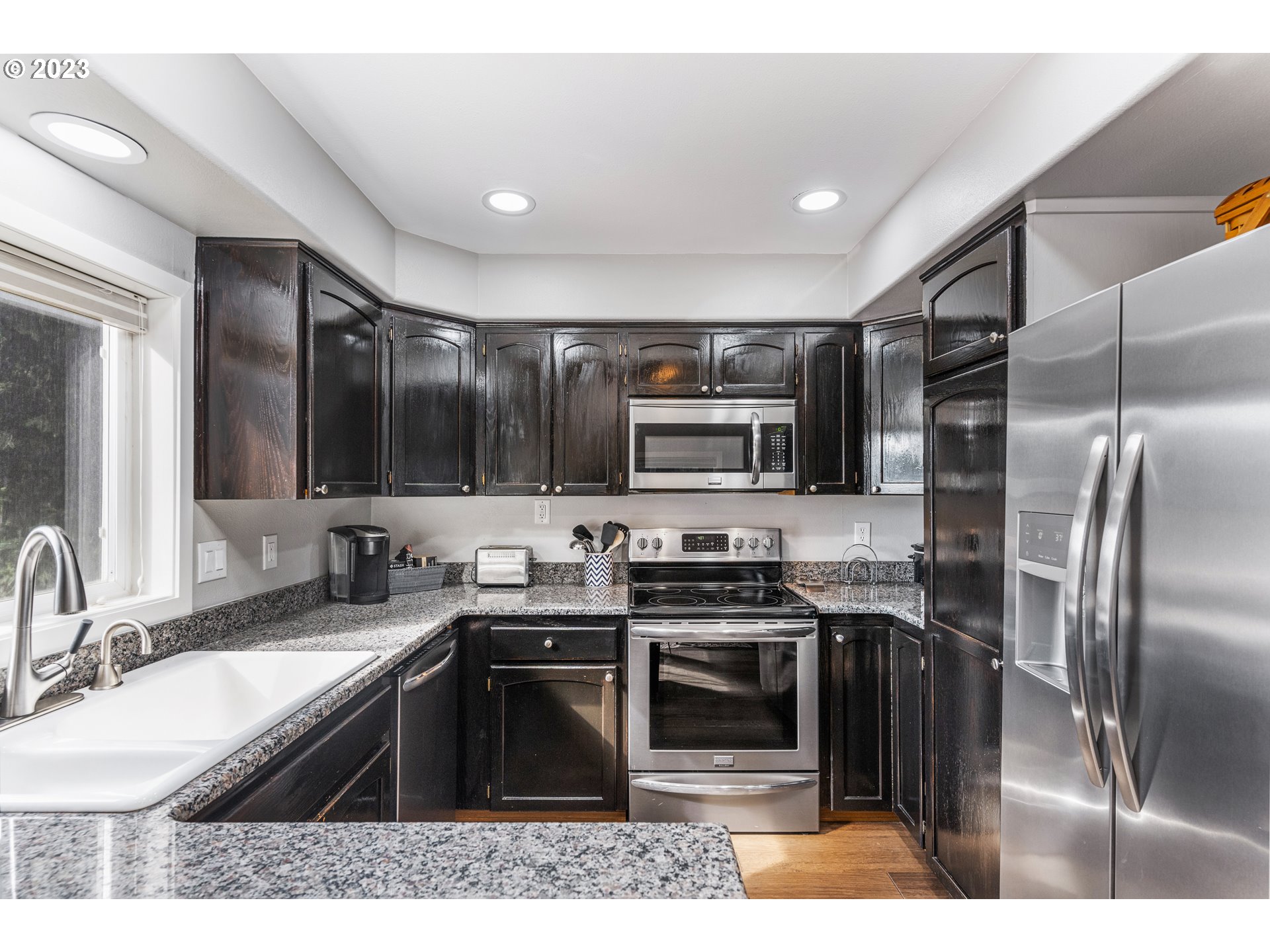 5963 Timber Ridge Drive Southeast Salem, OR 97317 - Photo 20 of 39 a kitchen with stainless steel appliances granite countertop a sink stove microwave and refrigerator