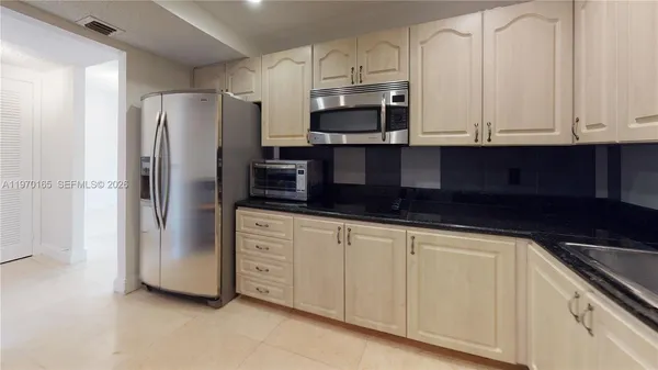 a kitchen with stainless steel appliances granite countertop a refrigerator and a stove top oven
