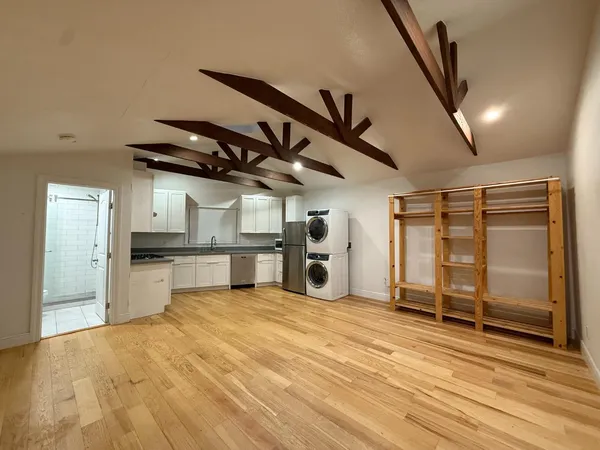 a view of a kitchen with a sink and a refrigerator