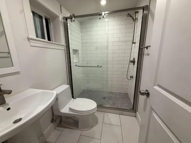 a bathroom with a shower a toilet and a sink
