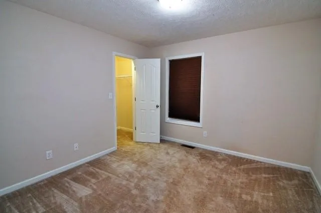 an empty room with closet and a window