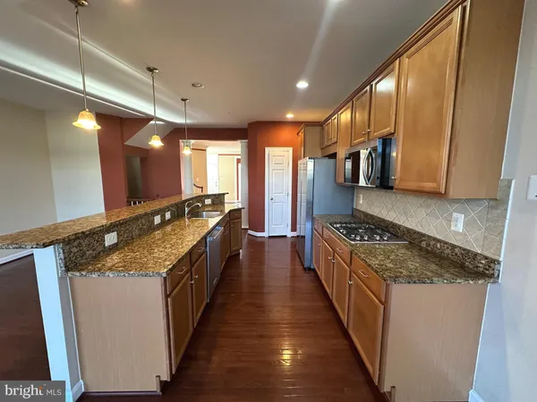 a large kitchen with stainless steel appliances granite countertop a stove and a sink