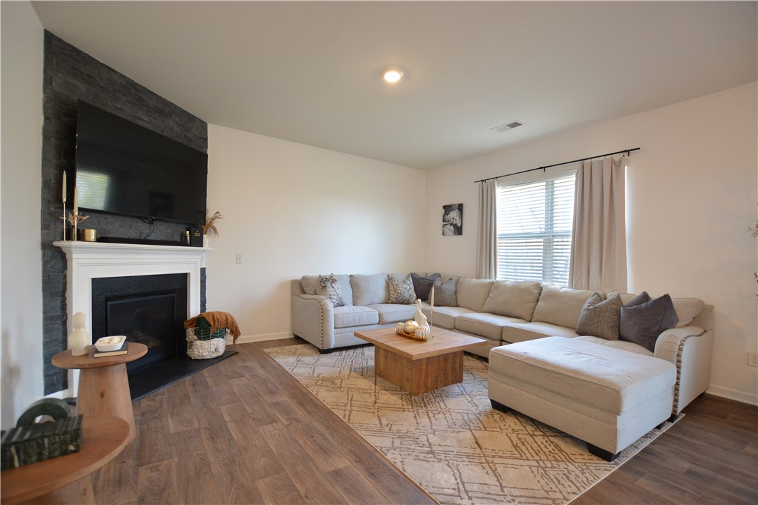 242 Hillendale Way Pelzer, SC 29669 - Photo 17 of 19 This inviting living room features warm flooring and a cozy fireplace, ideal for relaxing moments.