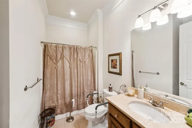 a bathroom with a granite countertop sink vanity mirror and toilet
