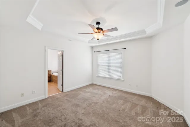 an empty room with closet and a ceiling fan