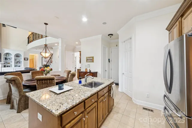 a living room with stainless steel appliances granite countertop furniture and a refrigerator