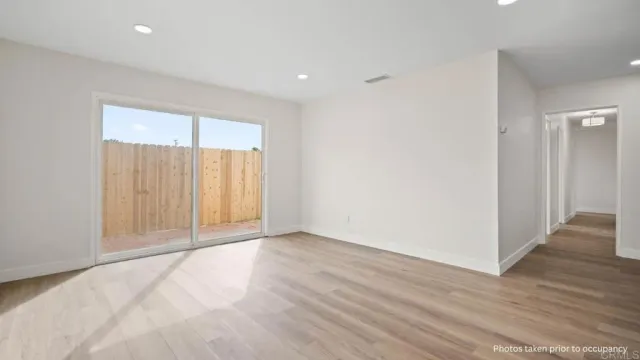 a view of an empty room with wooden floor
