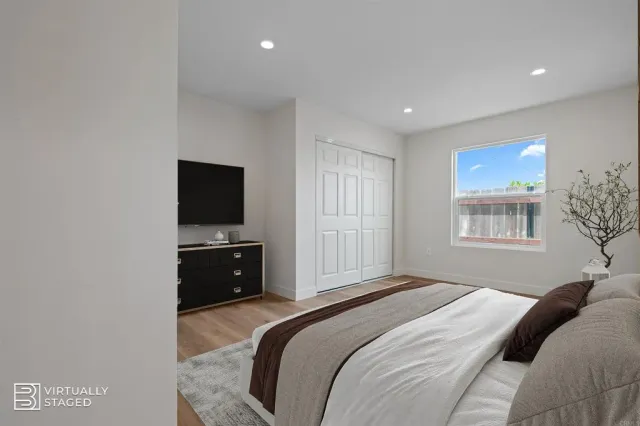 a bedroom with a bed and a flat screen tv