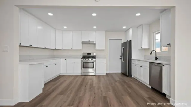 a kitchen with white cabinets stainless steel appliances and a refrigerator