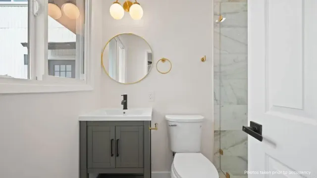 a bathroom with a toilet sink and mirror