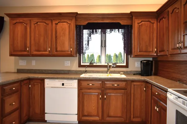 a kitchen with kitchen island a stove a sink and a refrigerator with wooden floor