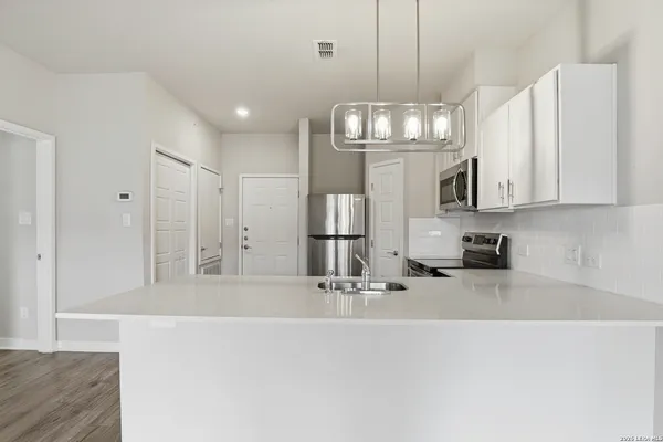 a kitchen with stainless steel appliances granite countertop a microwave a stove and white cabinets
