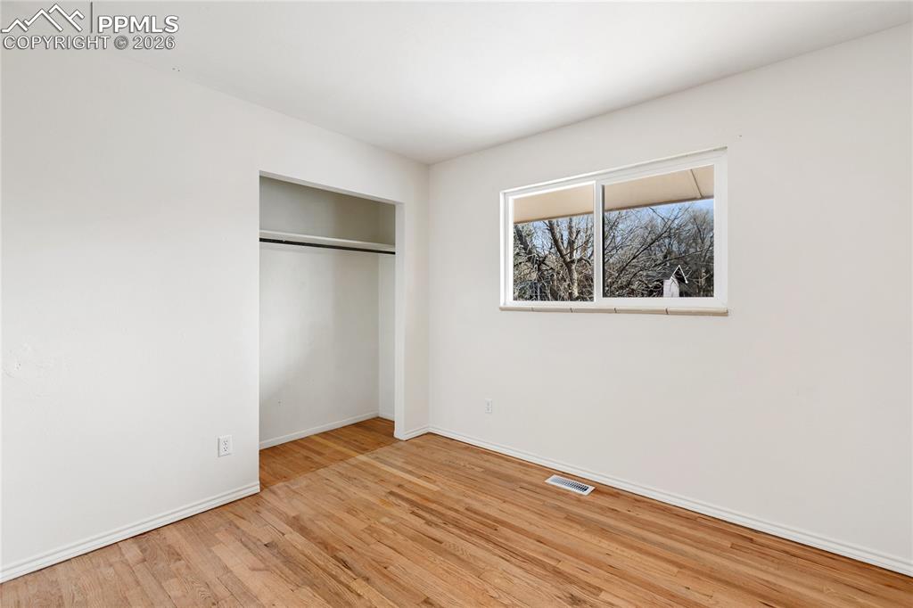528 Rowe Lane Colorado Springs, CO 80911 - Photo 19 of 38 a view of empty room with wooden floor and fan