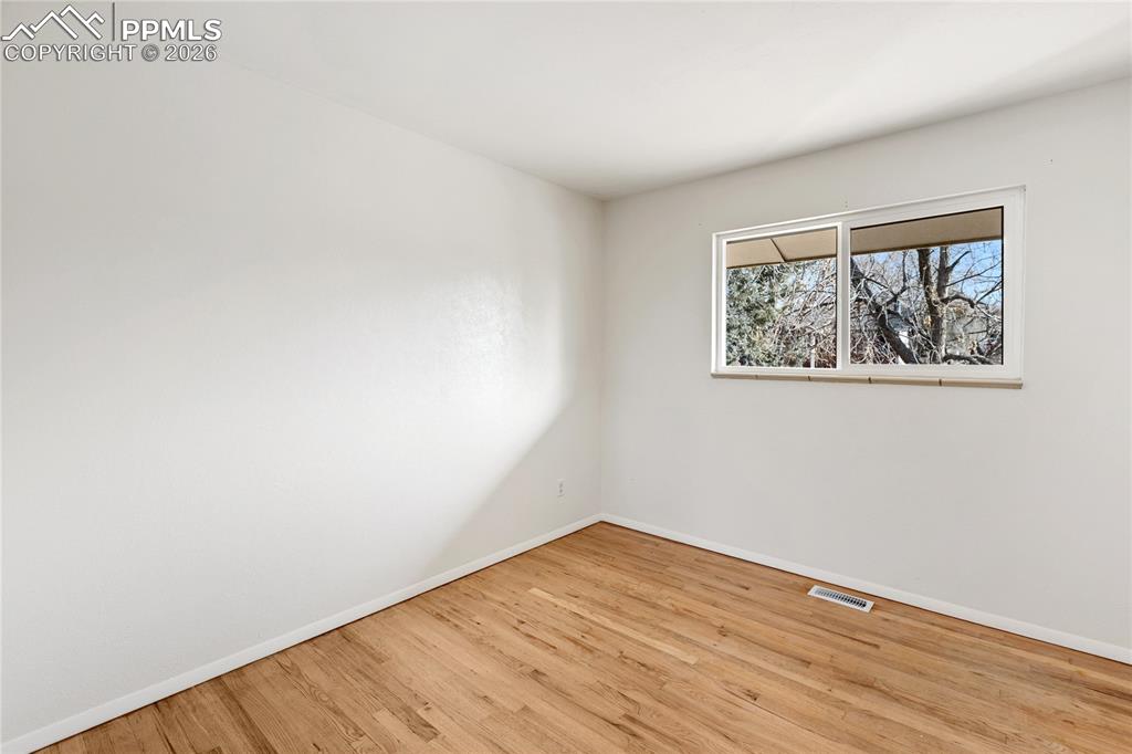 528 Rowe Lane Colorado Springs, CO 80911 - Photo 20 of 38 an empty room with wooden floor and windows