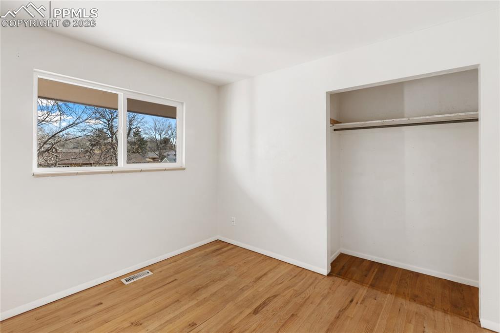 528 Rowe Lane Colorado Springs, CO 80911 - Photo 21 of 38 a view of an empty room with wooden floor and a window