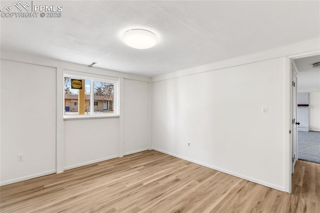528 Rowe Lane Colorado Springs, CO 80911 - Photo 26 of 38 an empty room with wooden floor and windows