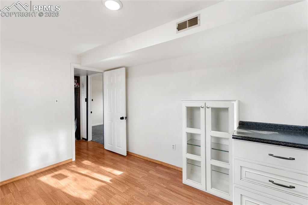 528 Rowe Lane Colorado Springs, CO 80911 - Photo 31 of 38 a view of empty room with wooden floor and cabinet
