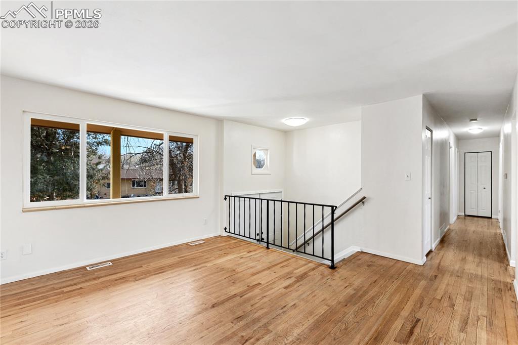 528 Rowe Lane Colorado Springs, CO 80911 - Photo 7 of 38 a view of an empty room with wooden floor and a window