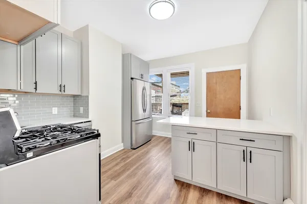 a kitchen with white cabinets and appliances