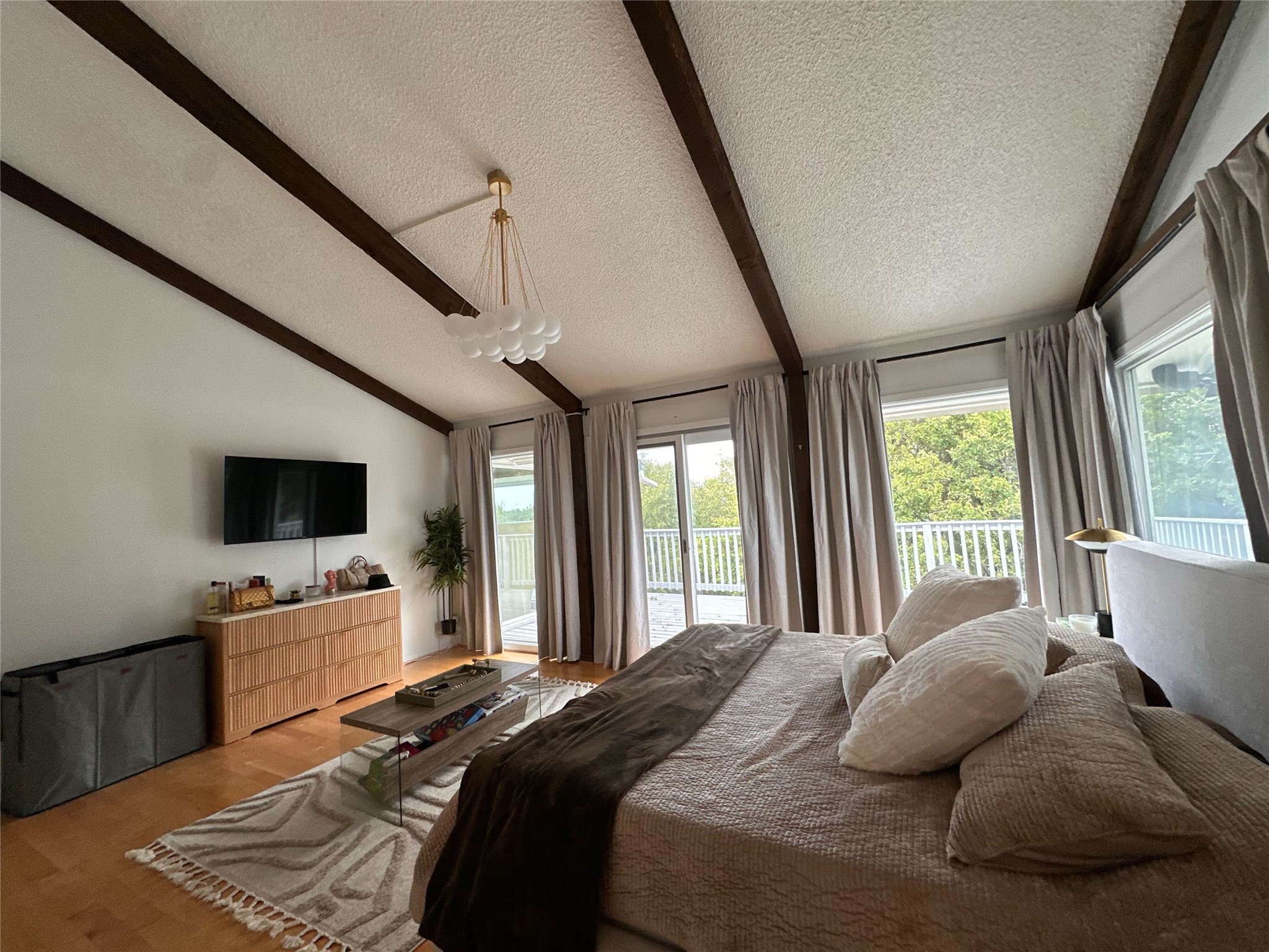 1302 Ridgecrest Drive Austin, TX 78746 - Photo 13 of 19 Exposed wood beams and vaulted ceilings bring architectural character to this bedroom suite.