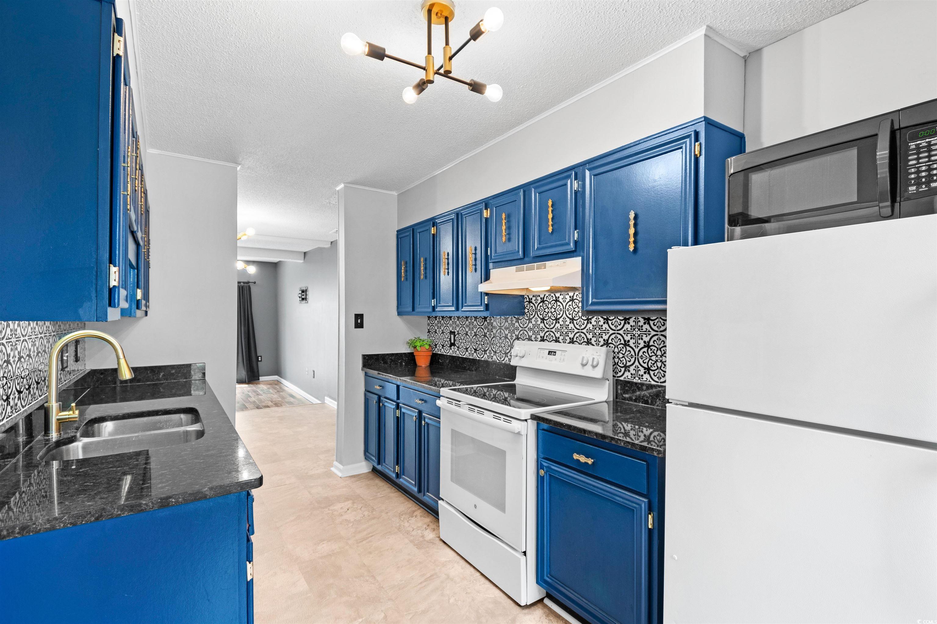 Kitchen featuring tasteful backsplash, blue cabine