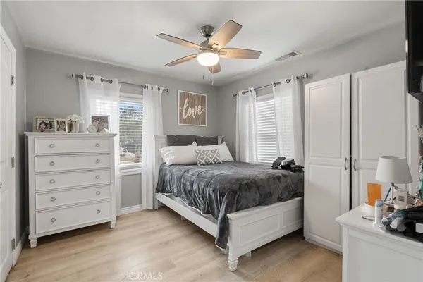 a spacious bedroom with a bed and a ceiling fan