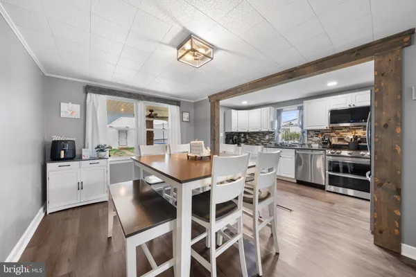 a kitchen with a dining table chairs stainless steel appliances and cabinets