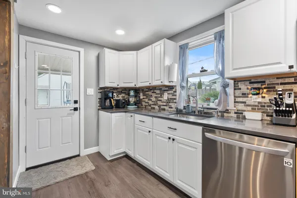 a kitchen with stainless steel appliances granite countertop a sink a stove and cabinets