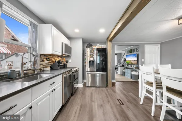 a large kitchen with stainless steel appliances granite countertop a lot of counter space and wooden floors