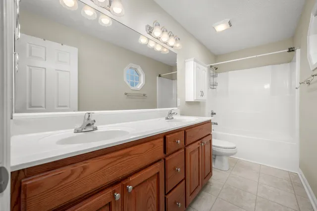 a bathroom with a sink a toilet a tub and a mirror