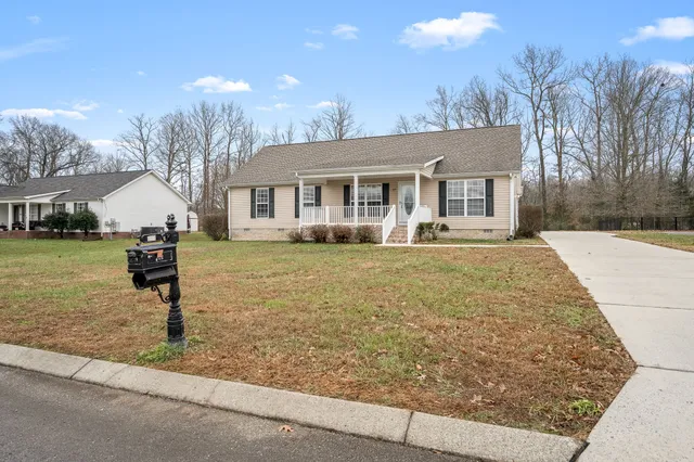 a front view of house with yard and trees around