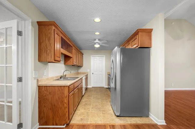 a kitchen with stainless steel appliances granite countertop a refrigerator a sink and a stove