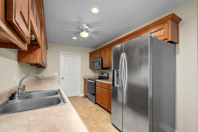 a kitchen with stainless steel appliances granite countertop a sink and refrigerator
