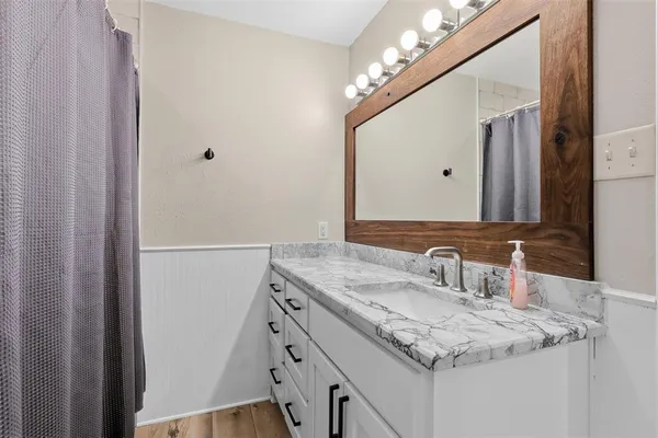 a bathroom with a sink vanity and a mirror