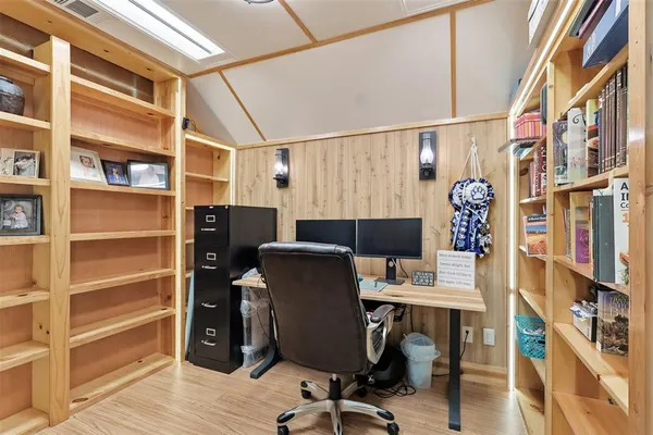 a view of a workspace with furniture and a window